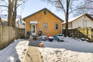 a yellow house with a wooden fence in the snow at Retro-Inspired Indy Home Walk to Fountain Square! in Indianapolis