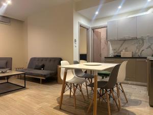 a kitchen and living room with a table and chairs at Kinfeels’ Downtown Suite ( K3 ) in Larisa