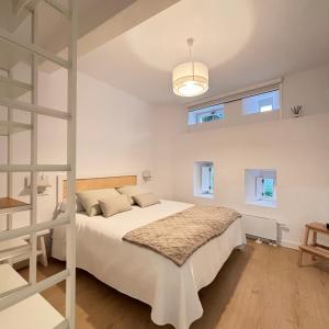 a bedroom with a bed and a ladder and windows at NOiTE 1 in Pontevedra