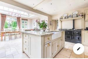 a large kitchen with white cabinets and a large island at Helmdon House Bed and Breakfast in Helmdon