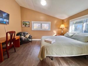 Schlafzimmer mit einem Bett, einem Schreibtisch und einem Stuhl in der Unterkunft Newly Renovated Home in Central Aurora in Aurora