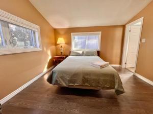 ein Schlafzimmer mit einem Bett und zwei Fenstern in der Unterkunft Newly Renovated Home in Central Aurora in Aurora