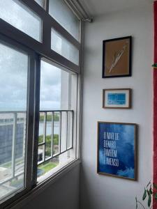 uma janela num quarto com um relógio na parede em Veja o mar no silêncio do centro! Hospede-se no quarto no Recife