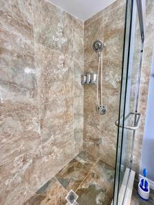 ein Bad mit einer Dusche und einer Glastür in der Unterkunft Newly Renovated Home in Central Aurora in Aurora