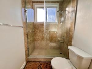 un bagno con doccia, WC e finestra di Newly Renovated Home in Central Aurora a Aurora Altre 27 foto