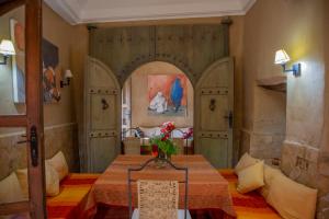 タルーダントにあるDar Les Dattiersのテーブルと2つのドアが備わる部屋