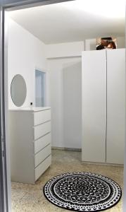 ローマにあるCasualSuiteRadioの白いキャビネットと敷物が備わる客室です。
