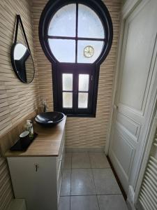 a bathroom with a sink and a window at Entre 2 flots 2 in Le Tréport