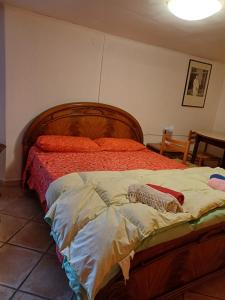 a bedroom with a large bed with a wooden headboard at Etnalcantara in Castiglione di Sicilia