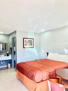 1 dormitorio con 1 cama y 1 mesa en Palace Motel DEQUEEN, en De Queen