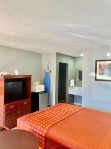 Habitación de hotel con cama y TV en Palace Motel DEQUEEN, en De Queen