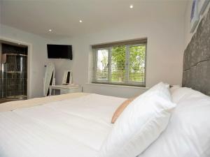 um quarto com uma grande cama branca e uma janela em 4 bed in Oswestry 74982 em Kinnerley