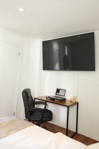 una camera da letto con scrivania, computer portatile e sedia di American Dream Guest House a New York