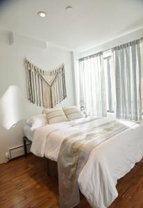 a white bedroom with two beds and a window at American Dream Guest House in New York