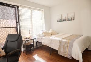 ein Schlafzimmer mit einem Bett, einem Stuhl und einem Fenster in der Unterkunft American Dream Guest House in New York