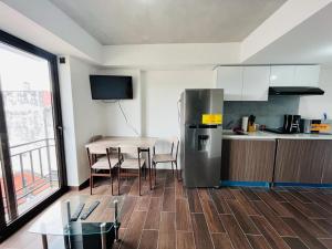 uma cozinha com uma mesa e um frigorífico de aço inoxidável em Apartamento zona 1, Ciudad de Guatemala em Guatemala