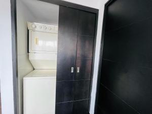 Una puerta negra en una cocina con lavadora y secadora. en Apartamento zona 1, Ciudad de Guatemala, en Guatemala