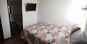 um quarto com uma cama com uma colcha em Apartamento zona 1, Ciudad de Guatemala em Guatemala