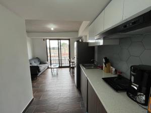 a kitchen with a counter and a living room with a couch at Apartamento zona 1, Ciudad de Guatemala in Guatemala