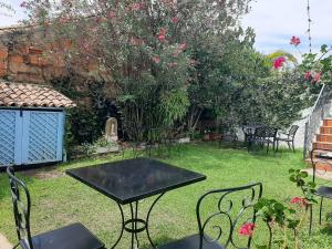 een patio met een tafel en stoelen in een tuin bij Hotel Casa Boutique Villa de Leyva in Villa de Leyva