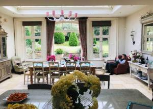 uma sala de estar com mesa e pessoas sentadas em Helmdon House Bed and Breakfast em Helmdon