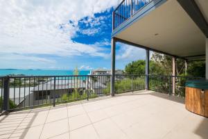 an expansive balcony with a view of the water at Holiday on The Horizon Airlie Beach Holiday Home in Airlie Beach