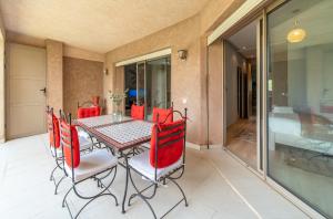 uma sala de jantar com uma mesa e cadeiras vermelhas em Relaxing Summer-Pool-Garden-Wifi em Marrakech