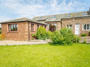 a brick house with a green lawn in front of it at 3 bed property in Wigton 83471 in Aikton