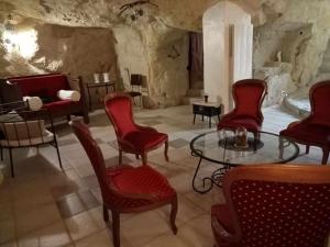 een kamer met stoelen, een tafel en een bed bij Esprit Troglo in Beaumont-en-Véron