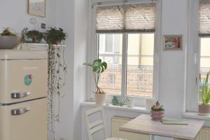 una cucina con frigorifero e tavolo con piante in vaso di Großes, helles Zimmer mit privatem Bad in Villa a Gotha