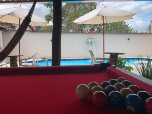 a pool table with balls in front of a swimming pool at Casa 2M no Centro de Piri in Pirenópolis