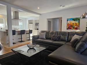 a living room with a leather couch and a table at Residence Orleans (inground pool) in Sainte-Petronille