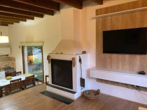 sala de estar con chimenea y TV de pantalla plana en Departamento Base Cerro Catedral en San Carlos de Bariloche