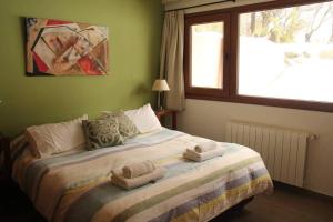 1 dormitorio con 1 cama con toallas en Departamento Base Cerro Catedral en San Carlos de Bariloche