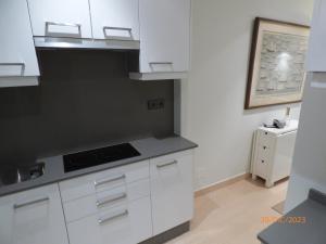 a kitchen with white cabinets and a black counter top at CASA MARIÑEIRA in Pobra do Caramiñal