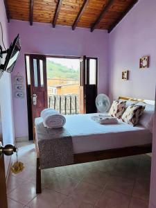 una camera da letto con un grande letto con pareti viola di B&B CALLE REAL a San Roque