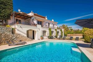 uma villa com piscina em frente a uma casa em Charming villa with sea view em Vallauris