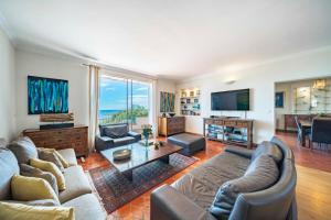 uma sala de estar com um sofá e uma mesa em Charming villa with sea view em Vallauris