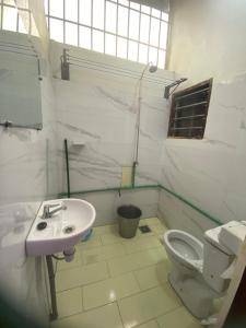 a white bathroom with a sink and a toilet at Moularid espace in Agblangandan