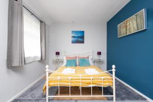 a bedroom with a bed with a blue wall at Entire home in Seacroft, Leeds, UK in Roundhay