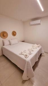 ein Schlafzimmer mit einem weißen Bett mit weißer Bettwäsche in der Unterkunft Kanui VK 102 Milagres - Duplex Perto da Capela e Raizeiros in São Miguel dos Milagres
