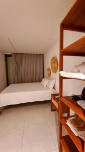 ein kleines Zimmer mit einem Bett und einem Regal in der Unterkunft Kanui VK 102 Milagres - Duplex Perto da Capela e Raizeiros in São Miguel dos Milagres + 21 Fotos