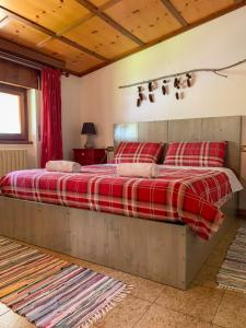 1 dormitorio con 1 cama grande con almohadas rojas en All'Ombra del Mortirolo, en Mazzo di Valtellina