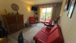 a living room with red chairs and a window at Ilimay Las Cruces in Las Cruces