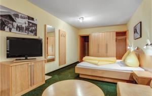 ザンクト・アントン・アム・アールベルクにあるNice Apartment In St, Anton With Kitchenetteのベッド1台、薄型テレビが備わる小さな客室です。