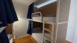 a small room with two bunk beds in it at VHostel in Guimarães