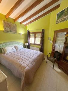 a bedroom with a large bed and yellow walls at Sweet Home in Pego