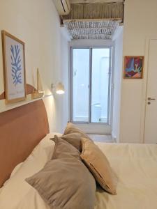 a bed with pillows in a room with a window at Hermoso dpto San isidro in San Isidro