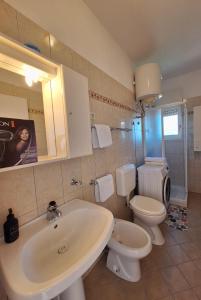 een badkamer met een witte wastafel en een toilet bij Apartmani Marini in Opatija
