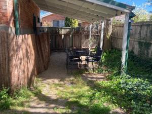 a patio with a table and chairs under a pergola at The Stables at Rosevale in Bathurst